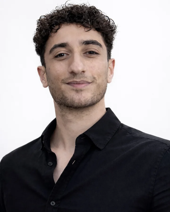 Kamyar, founder of Kavosh, smiling in a dark shirt.